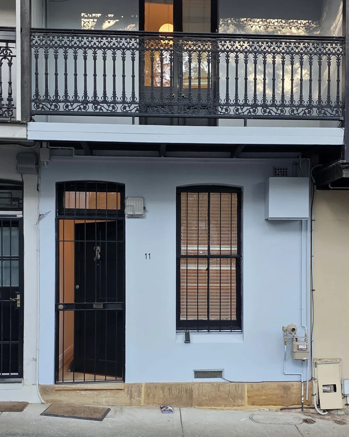 The same terrace facade after a full exterior repaint in soft blue grey, Sydney