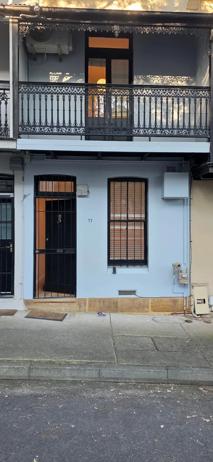 Exterior repaint, terrace facade in pale blue grey with black iron lacework, Sydney
