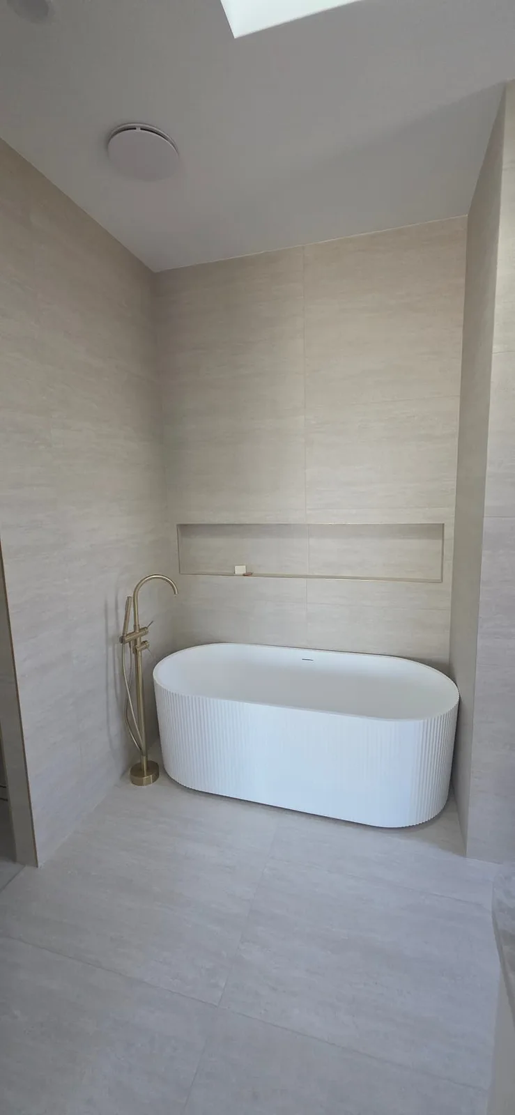 Interior repaint, bathroom with fluted freestanding bath under a skylight, Sydney