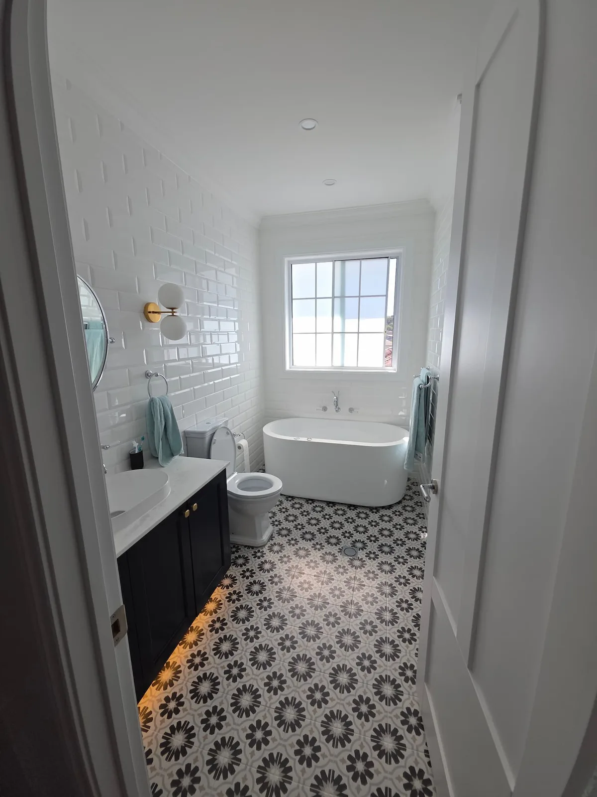 Interior repaint, white subway tiled bathroom with patterned floor and navy vanity, Sydney