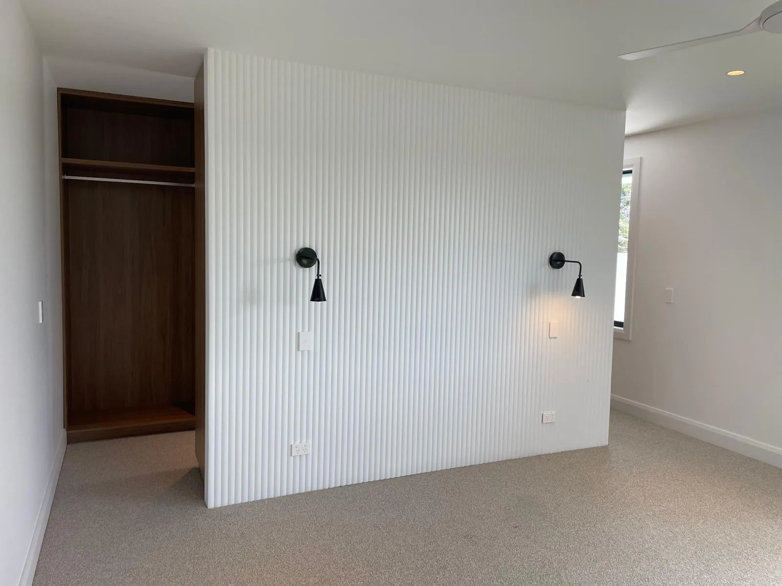 Interior repaint, bedroom with fluted feature wall and black sconces, Sydney