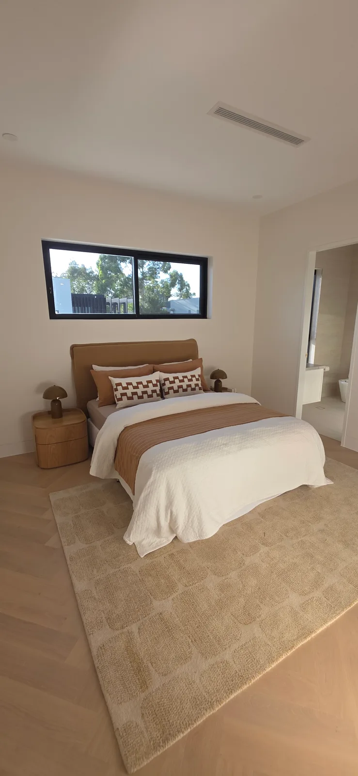 Interior repaint, bedroom with tan upholstered bedhead over herringbone oak, Sydney