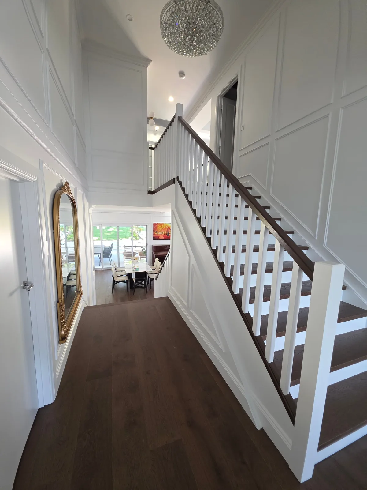 Interior repaint, panelled Hamptons entry with crystal chandelier and gilt mirror, Sydney