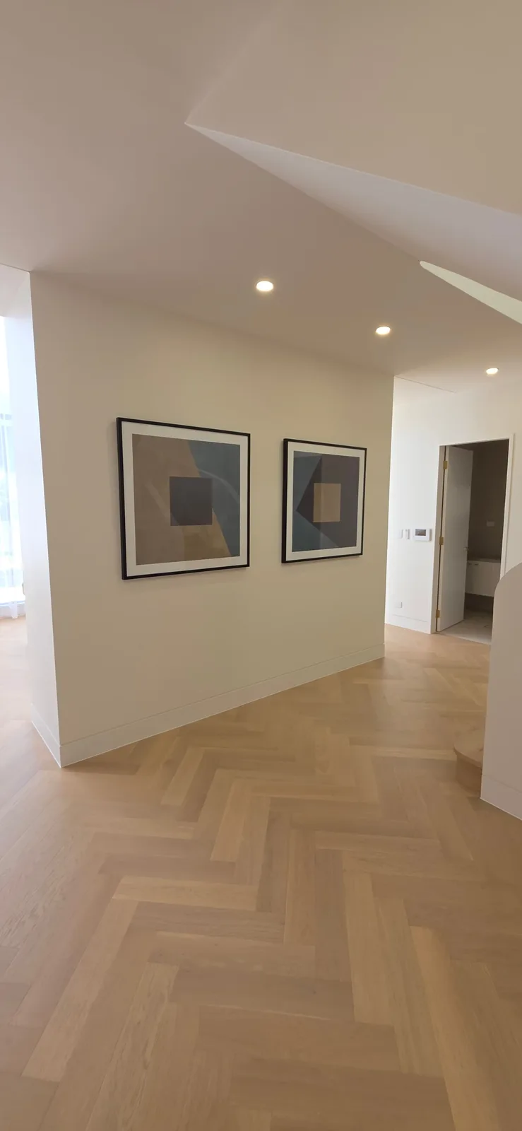 Interior repaint, hallway with paired artwork over herringbone oak, Sydney
