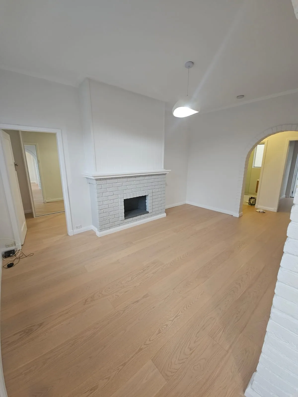 Interior repaint, living room with brick fireplace and archway, Sydney