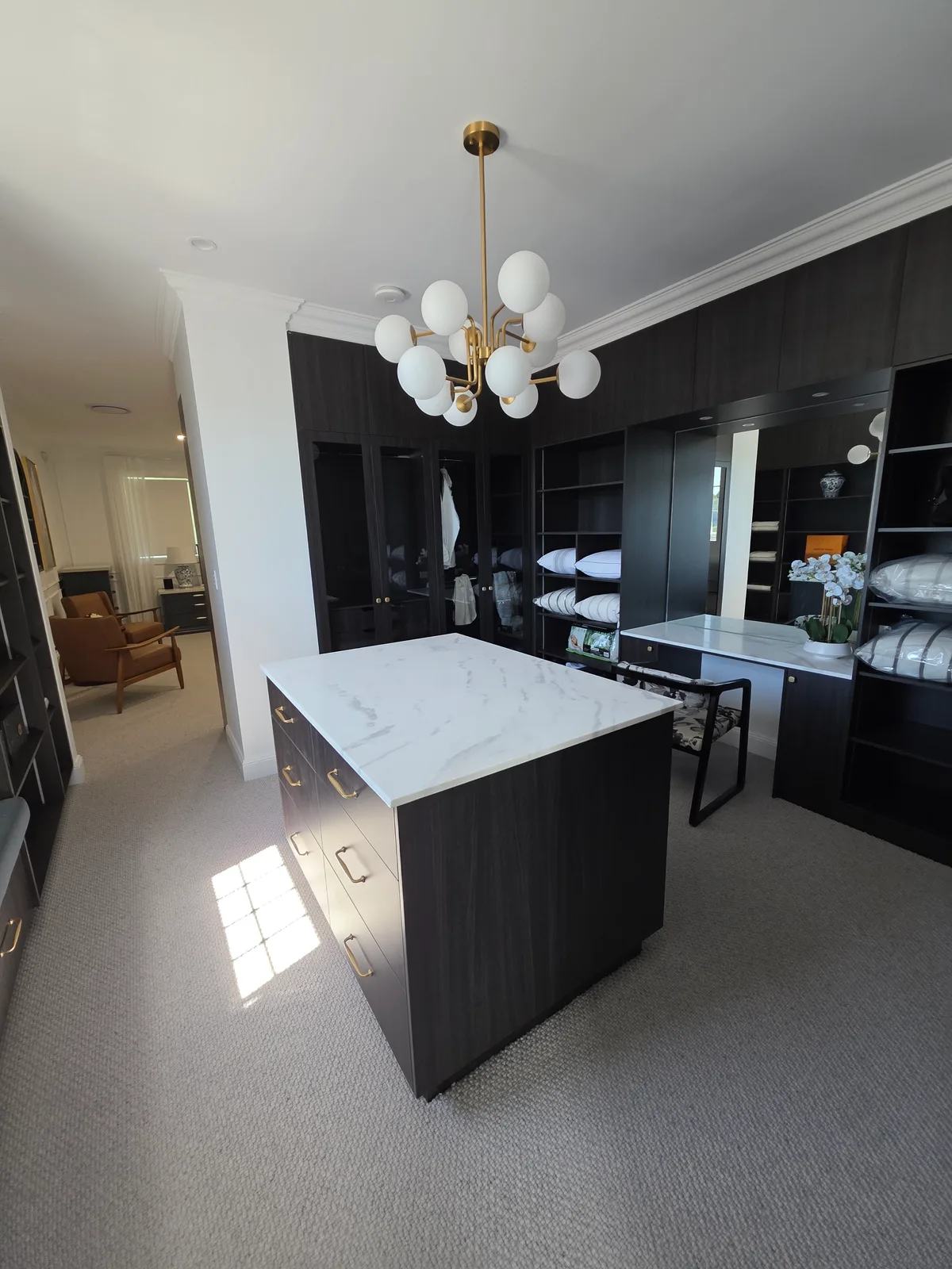 Interior repaint, dressing room with dark joinery and marble topped island, Sydney