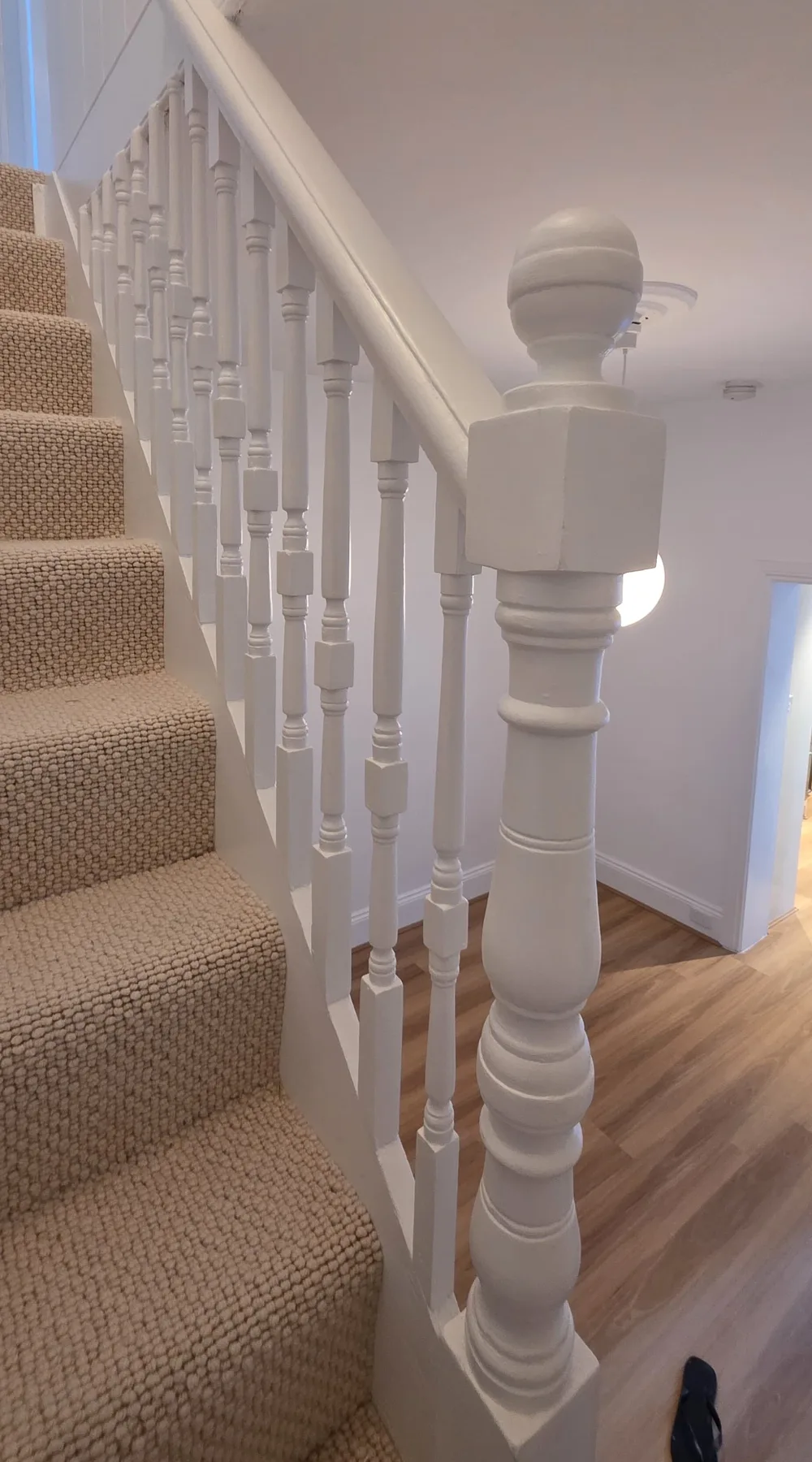 The same staircase balustrade and hallway after repainting, with new flooring laid, Sydney